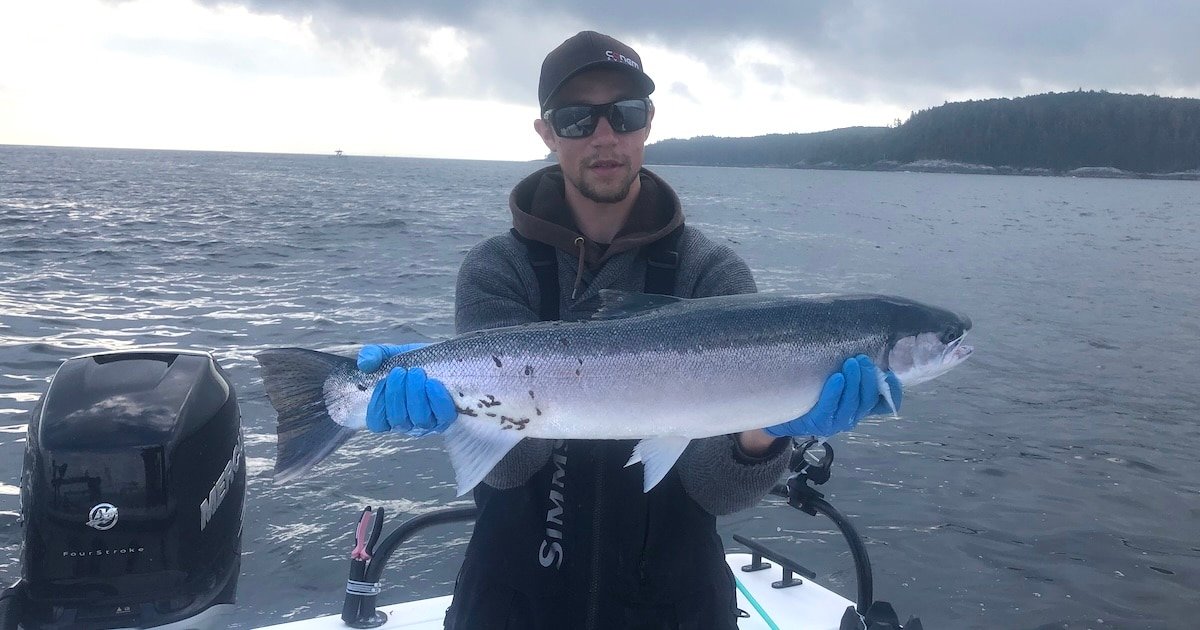 owen drisdale holding a steelhead caught at sea