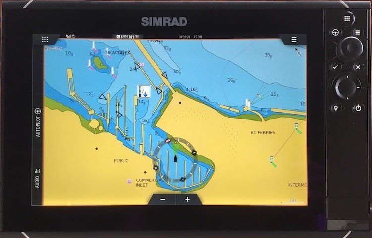 Simrad chart plotter displaying a detailed nautical map with navigational markers and waterway information.