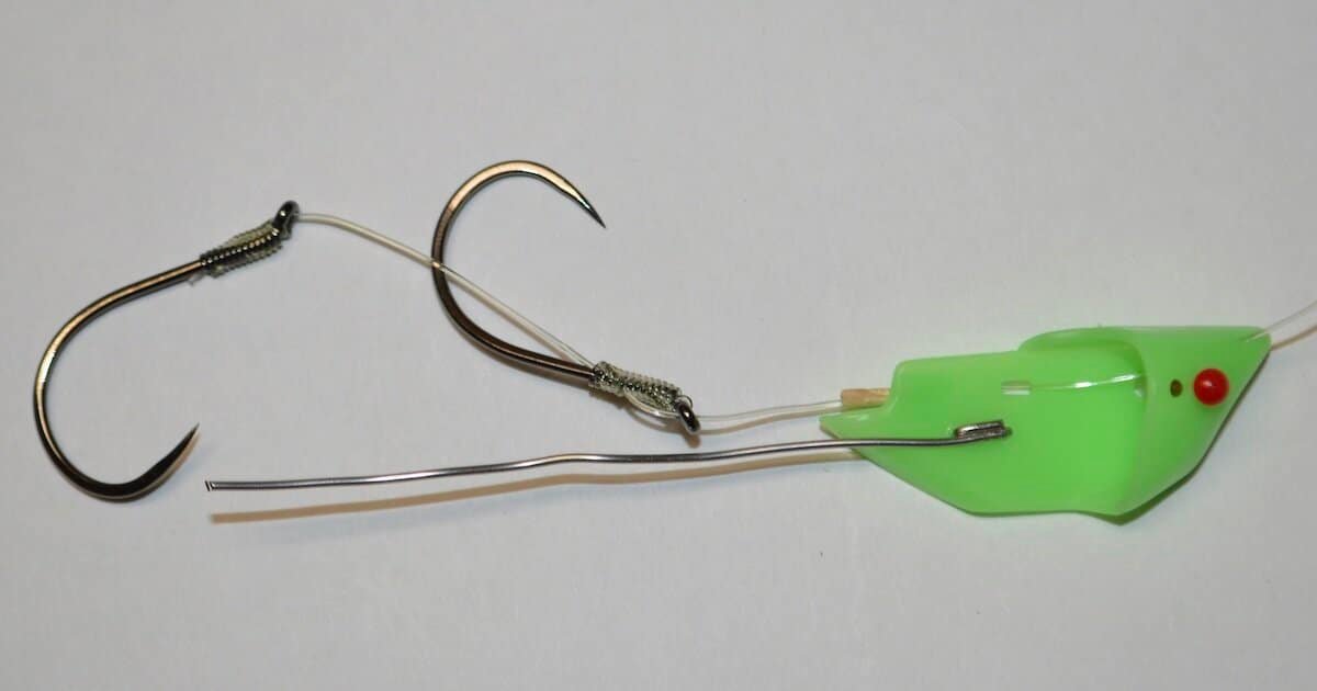 Green fishing lure with two barbless hooks attached, designed for catching fish in freshwater or saltwater environments.