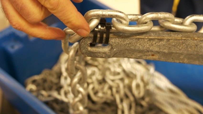 A close up claw anchor rigged for halibut anchoring with a breakaway chain and a heavy-duty zap straps. This setup shows the anchor chain secured to the crown for safe retrieval in BC tidal waters.