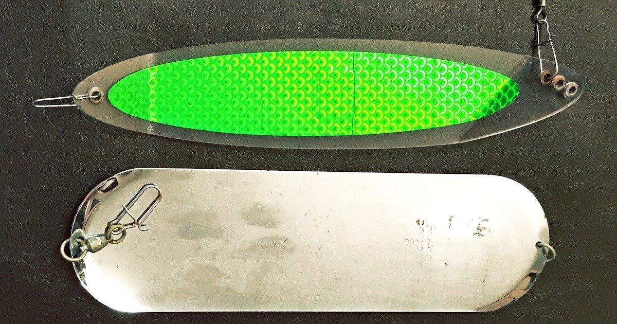 Two fishing dodgers, one with a green textured surface and the other a smooth metallic finish, used in fishing techniques.