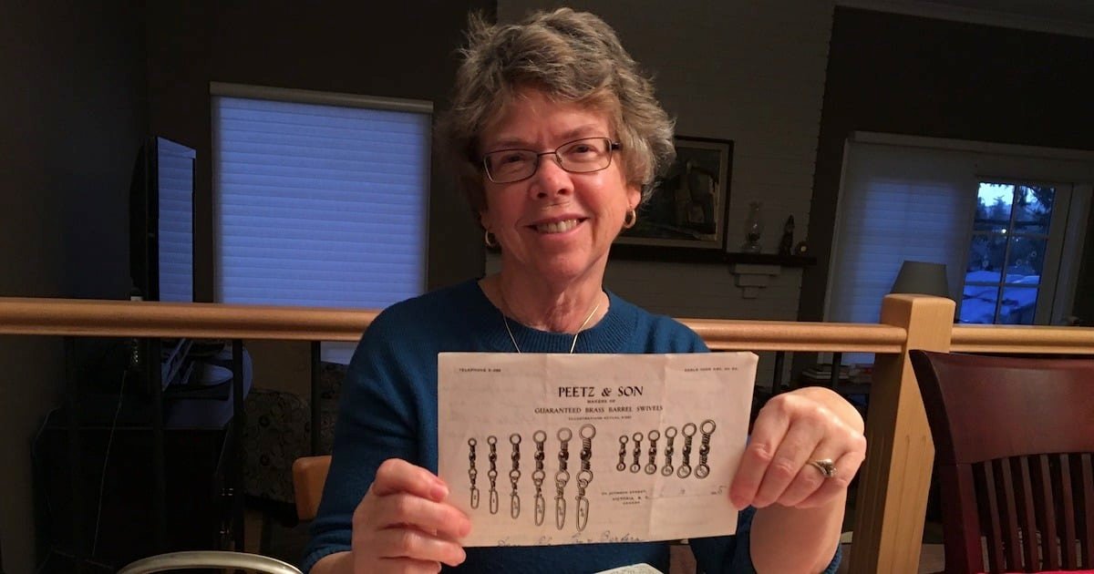 Woman holding a printed document with illustrations of fishing tackle components from Peetz & Son.