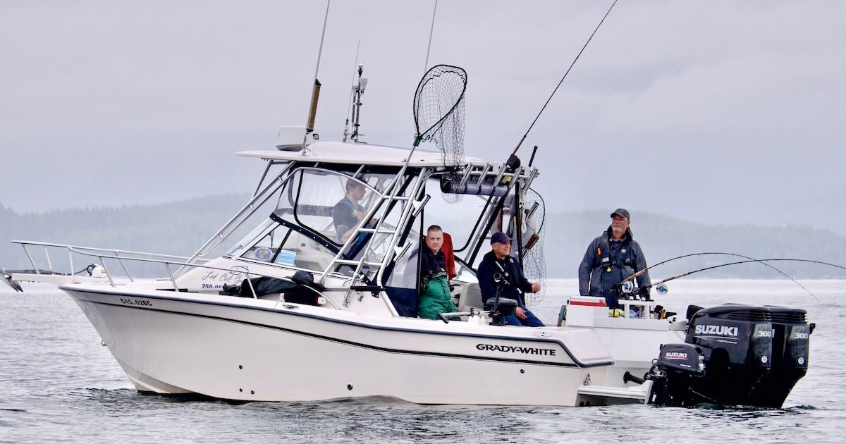 Grady-White fishing boat on water with three anglers, fishing gear, and an outboard motor visible.