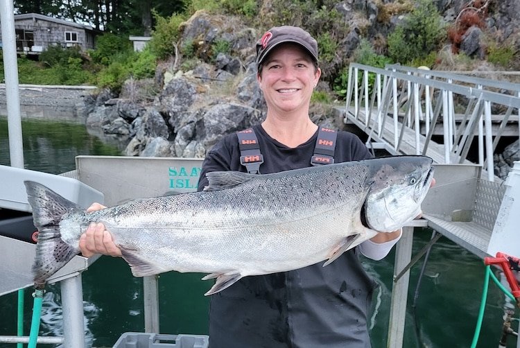 Angler Kristen Shardlow holding a large hatchery-produced Chinook salmon, highlighting the success of BC recreational fisheries.